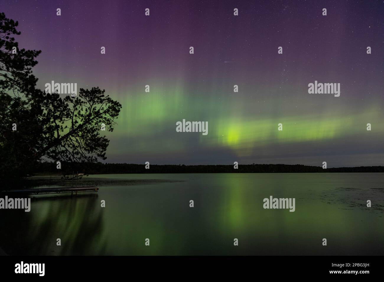 Les aurores boréales éclatent dans un ciel lumineux d'aurores au-dessus du lac du Nord du Minnesota Banque D'Images
