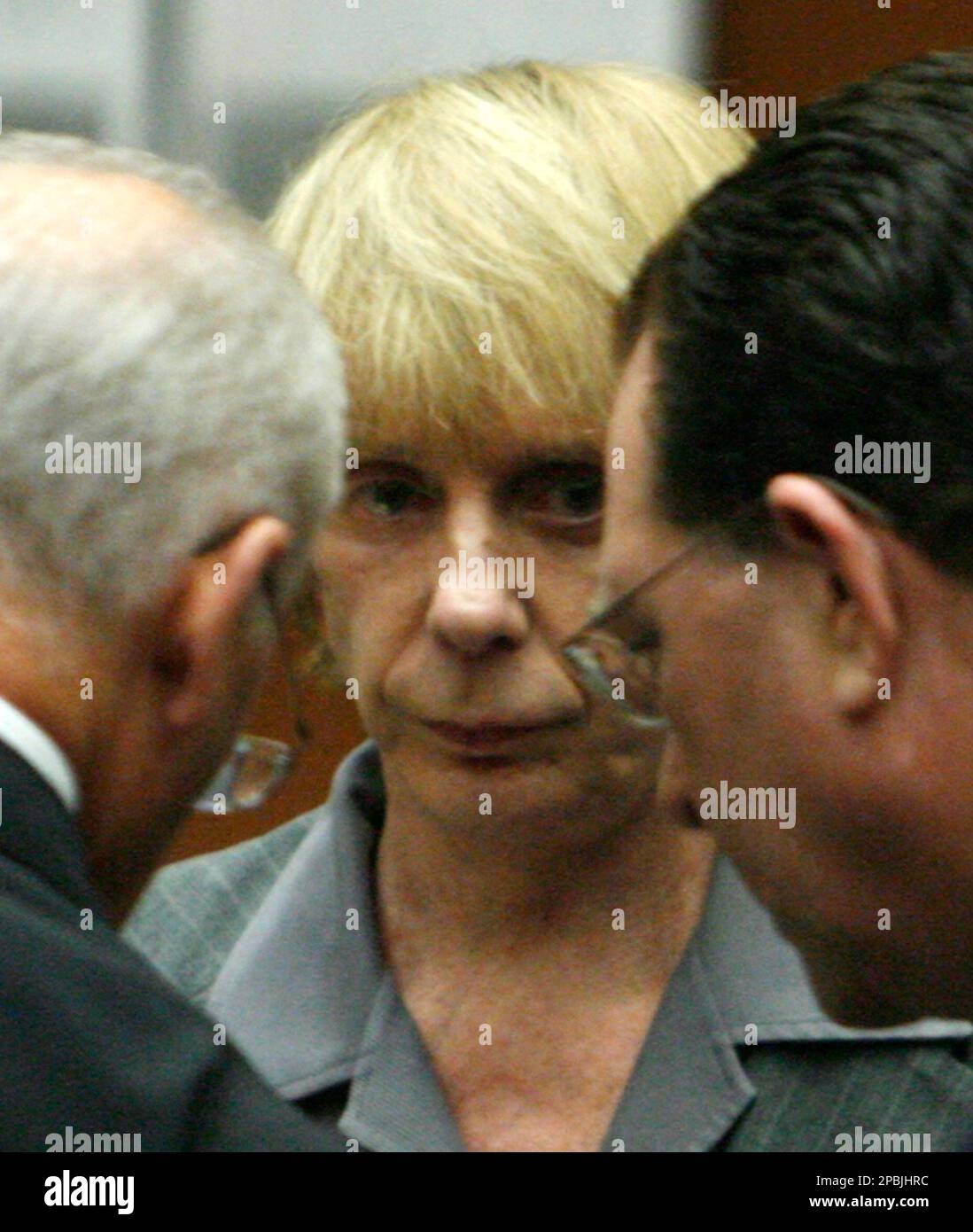 Music producer Phil Spector, center, listens as his attorney Roger