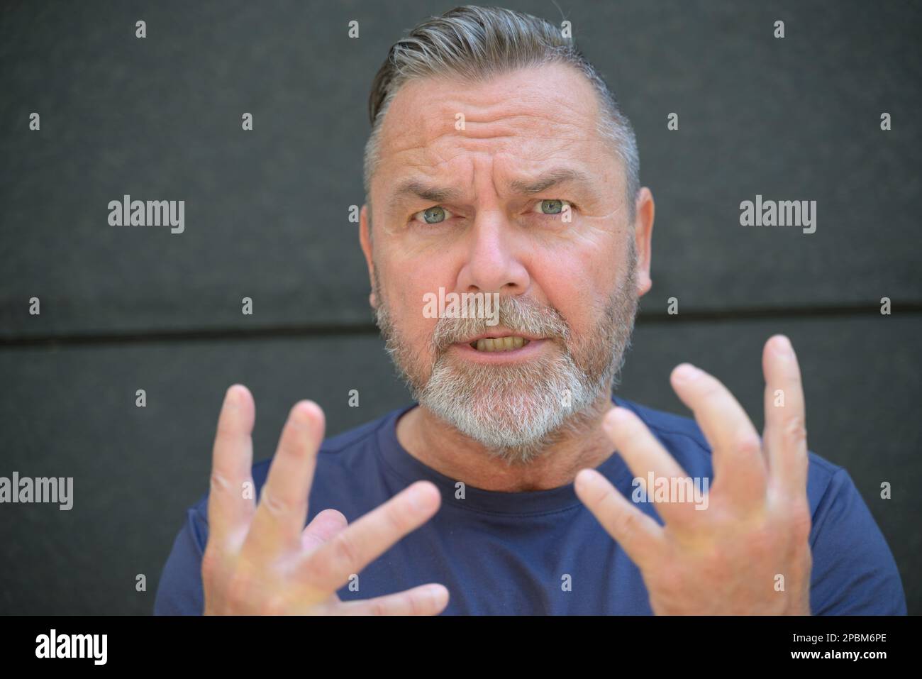 Homme argumentatif faisant un point en se mettant les doigts à la caméra comme il parle en gros plan Banque D'Images