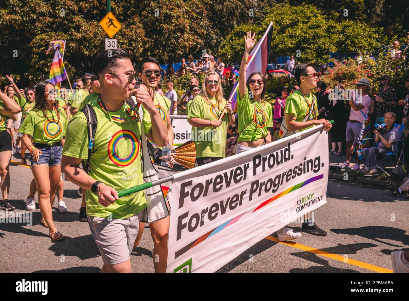 Vancouver, Canada - 31 juillet,2022: Les gens marchent sur la rue Pacific avec un énorme panneau Forever Proud(TD) pendant la parade de la fierté Banque D'Images