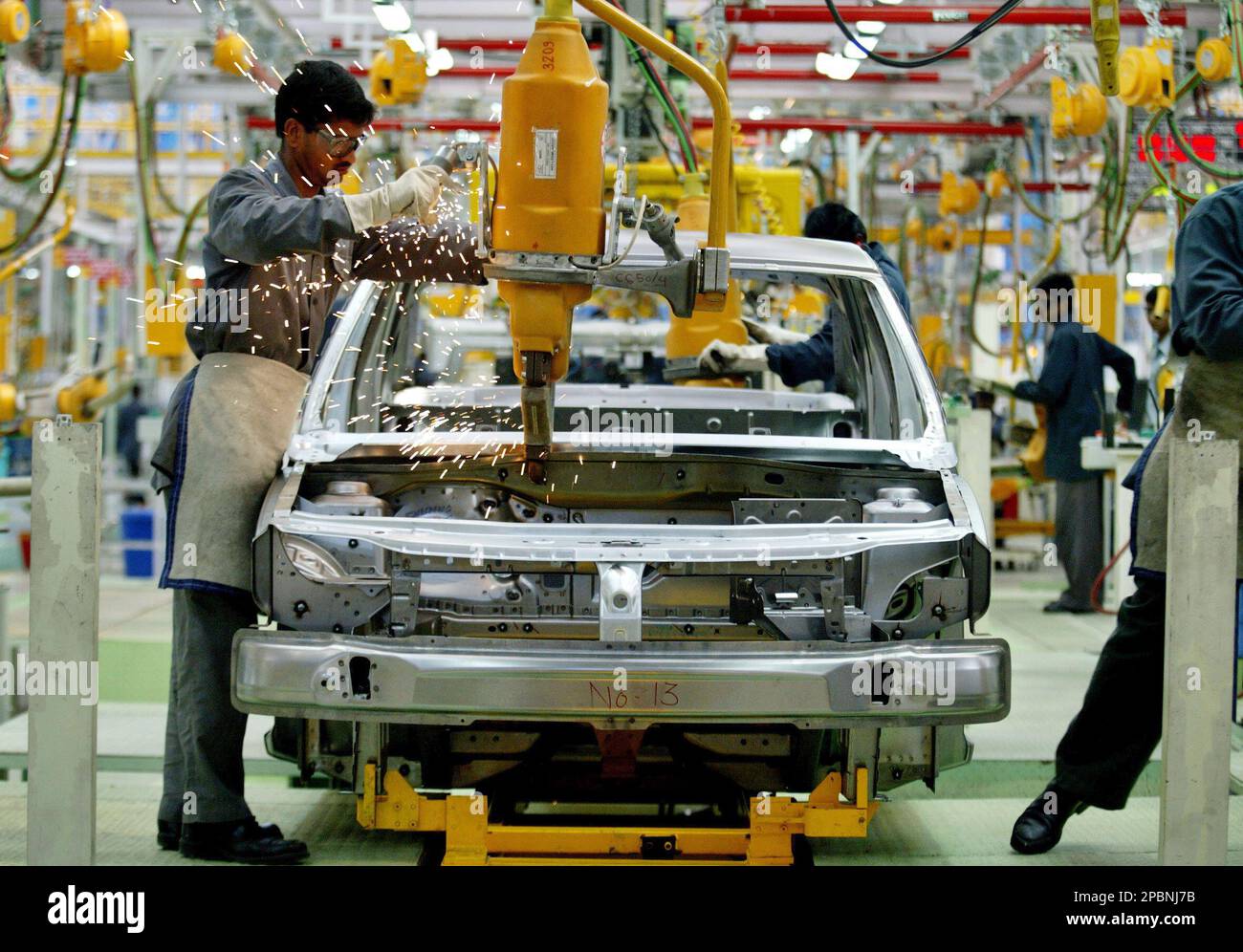 An employee works on a Logan at the assembly line at the Mahindra & Mahindra (M&M) plant near Nashik, about 200 kilometers (140 miles) northeast of Mumbai, India, Wednesday, April 4, 2007. France's Renault SA on Tuesday launched the low-cost sedan in India through a joint venture with local automaker M&M, boosting competition in the fast growing Indian market. The base model of the petrol variant of the Logan will cost 428,000 rupees (US$9,700) in Mumbai, while that of the diesel variant will be available for 547,000 rupees (US$12,400), said a statement from Mahindra Renault Ltd., a joint vent Banque D'Images