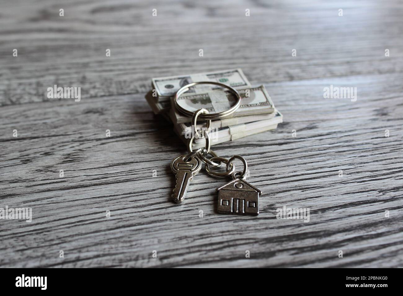 Image sélective du porte-clés en forme de maison et de la pile d'argent. Propriété de la maison et concept immobilier Banque D'Images