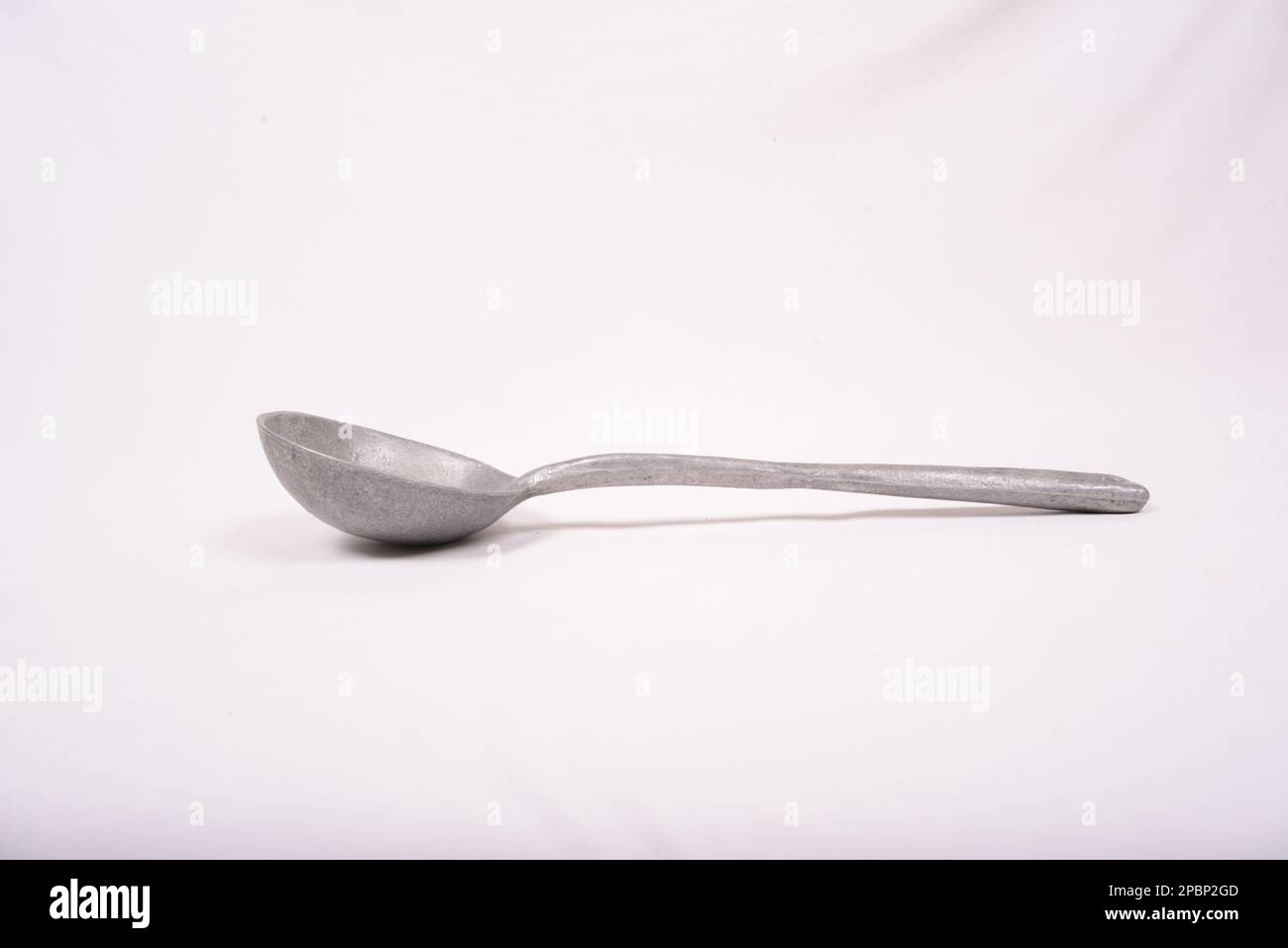 cuillère de service métallique sur fond blanc Banque D'Images