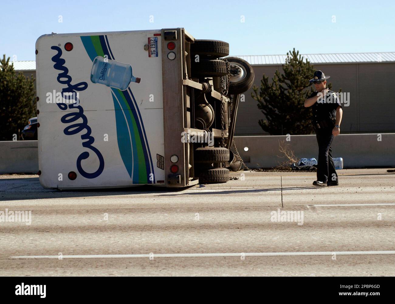 A transport truck for a bottled water company lies on its side after crossing two lanes of traffic and slamming into the median of the westbound lanes of Interstate 84, Thursday afternoon, March 29, 2007, in Boise, Idaho. Five-gallon water jugs were spread across the roadway in both directions, bringing rush-hour traffic to halt. (AP Photo/The Idaho Press-Tribune, Charlie Litchfield) ** MANDATORY CREDIT ** Thursday March 29, 2007 Banque D'Images