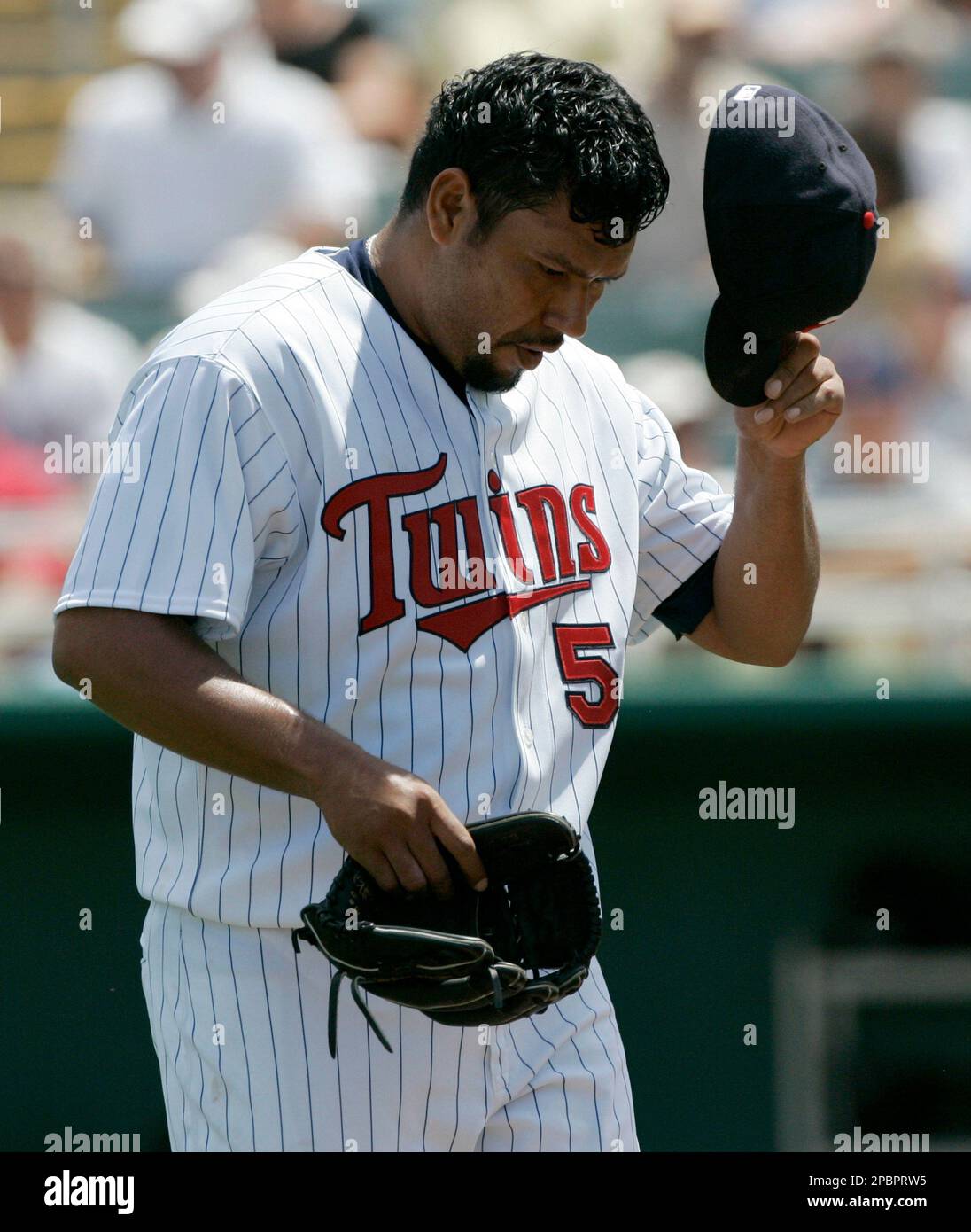 Minnesota Twins starter Carlos Silva takes off his cap as he walks off the field in the middle of the second inning after giving up a two-run home run to Pittsburgh Pirates' Brad Eldred in the second inning of their spring training baseball game in Fort Myers, Fla., Saturday March 24, 2007. Silva gave up nine runs on 11 hits in his three and a third inning outing. (AP Photo/Charles Krupa) Banque D'Images
