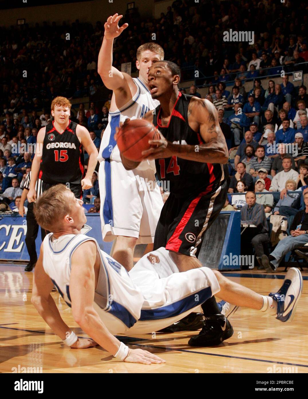 Georgia guard Levi Stukes (14) fouls Air Force forward Ryan Teets, bottom left, as Air Force center Nick Welch, back, and Georgia forward Steve Newman (15) look on during the first half of a second round NIT basketball game at Air Force Academy, Colo., Monday, March 19, 2007. (AP Photo/Jack Dempsey) Banque D'Images