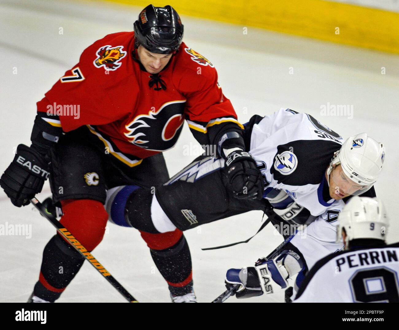 Tampa Bay Lightning Brad Richards, right, gets knocked to the ice by Calgary Flames' Andrei Zyuzin during first-period NHL hockey action in Calgary, Canada, Saturday, March 10, 2007. (AP Photo/Jeff McIntosh,CP) Banque D'Images