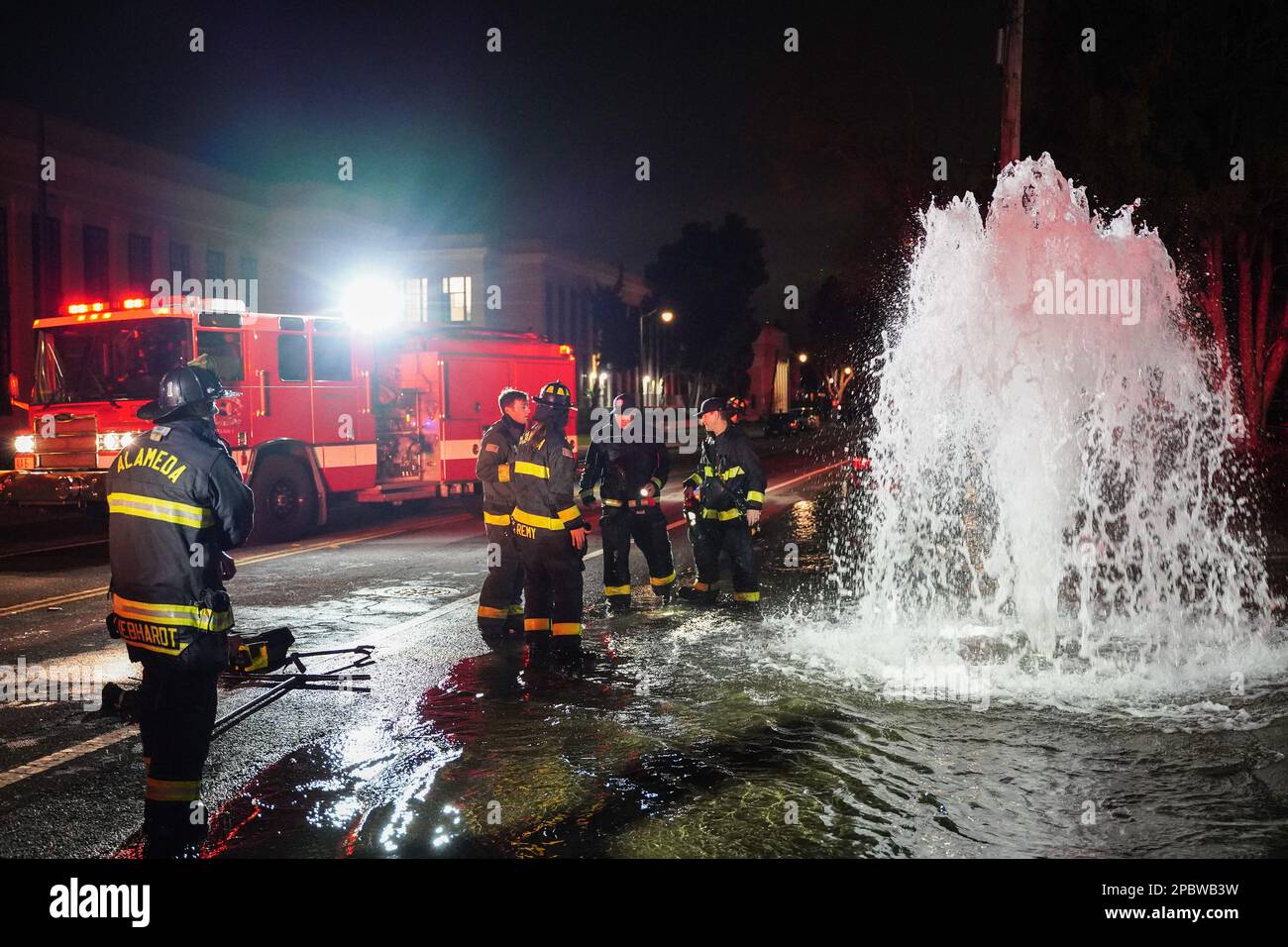 Les pompiers discutent de la solution pour arrêter l'eau. Une borne d'incendie située sur le bord de la route de Central Ave à Alameda, en Californie, a été écrasée par une voiture sur 12 mars. L'eau sous le poteau incendie est sortie et a inondé la route. Les pompiers d'Alameda ont répondu pour résoudre ce problème et ont empêché l'eau de sortir. (Photo de Michael Ho Wai Lee / SOPA Images/Sipa USA) Banque D'Images
