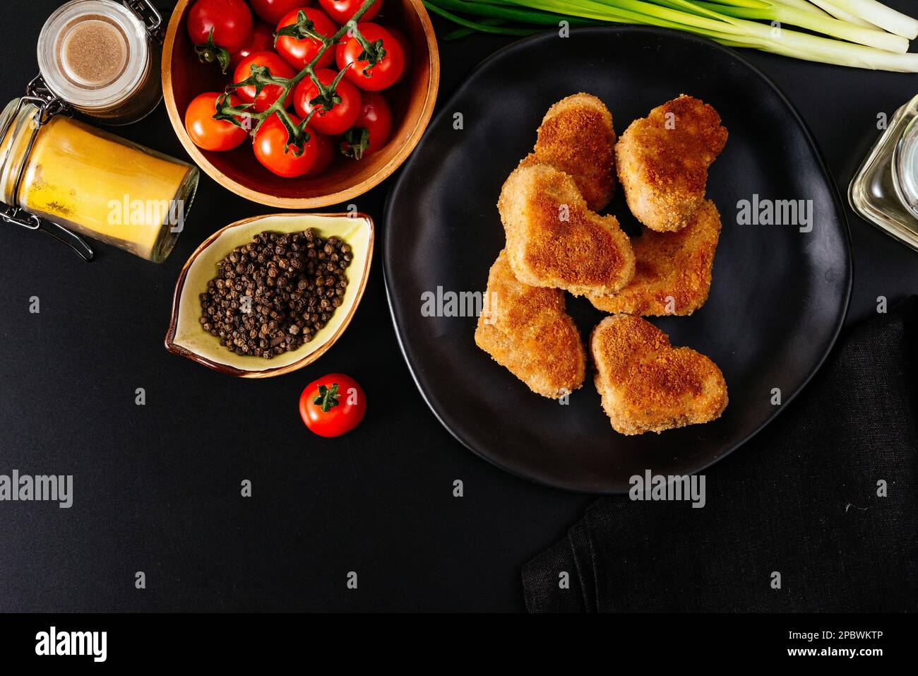 escalope de poulet sur une assiette noire. légumes et herbes. bac noir Banque D'Images