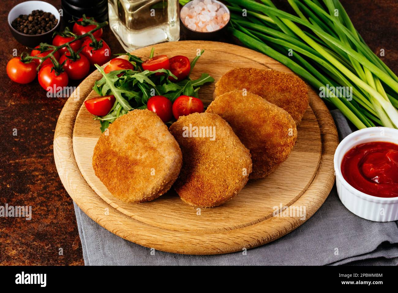 côtelette de poulet sur une planche en bois. légumes et herbes Banque D'Images