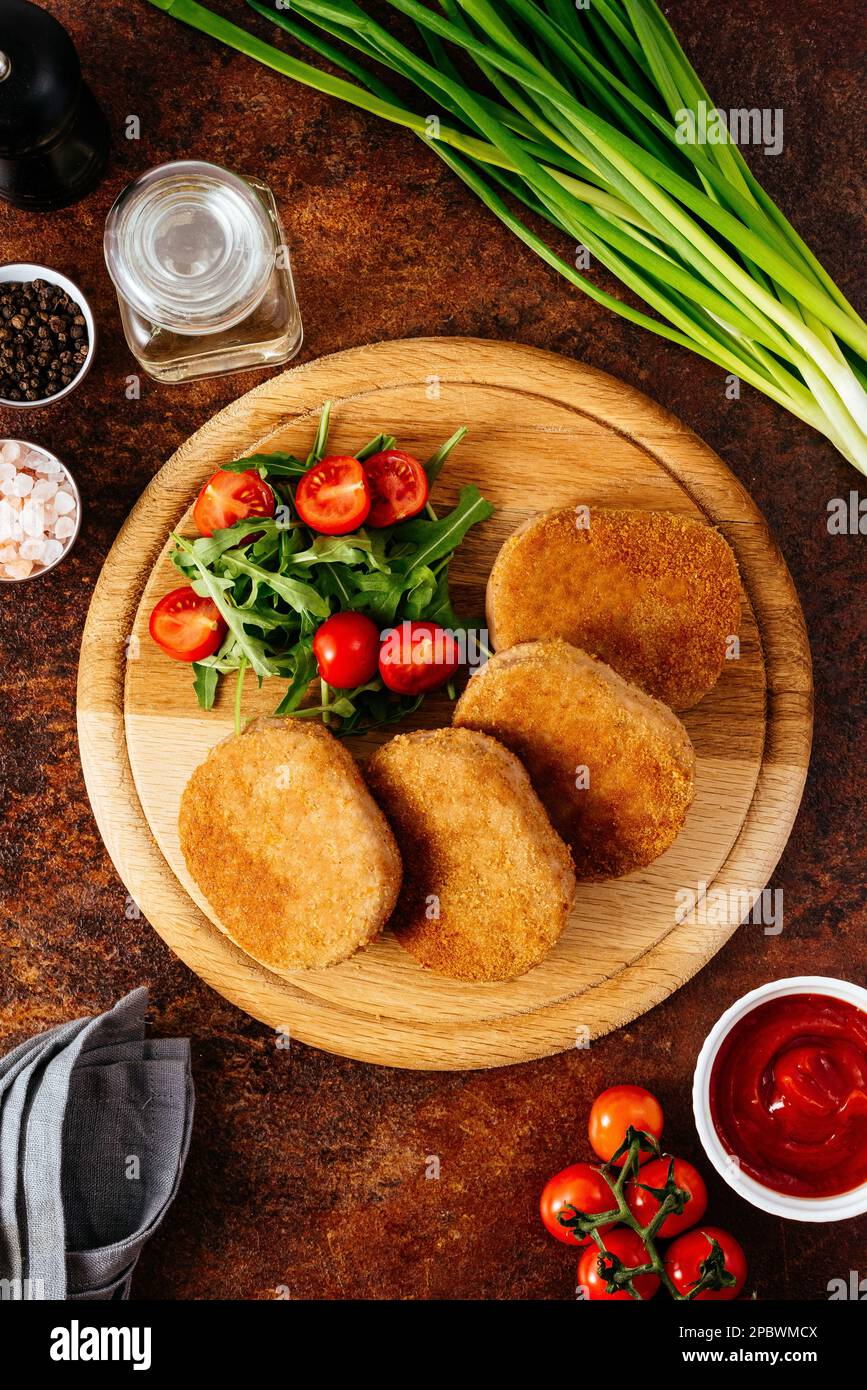 côtelette de poulet sur une planche en bois. légumes et herbes Banque D'Images