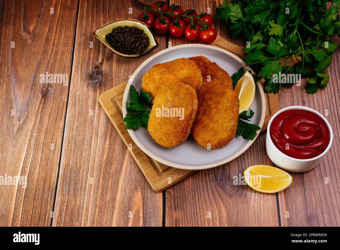 escalope de poulet sur une assiette. légumes et herbes. table en bois Banque D'Images