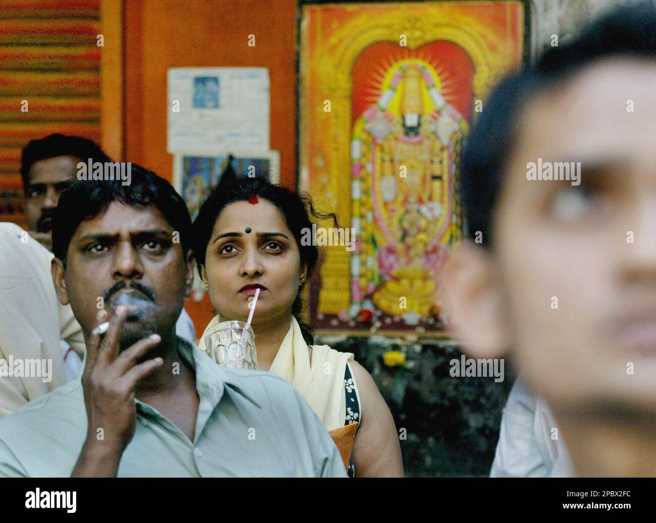 People watch a live telecast of Indian Finance Minister P Chidambaram delivering the Federal Budget speech on a screen put outside the Bombay Stock Exchange in Mumbai, India, Wednesday, Feb. 28, 2007. Indian stocks tumbled Wednesday, tracking losses on Wall Street and other regional markets and the market was volatile as investors waited for further cues, particularly from the federal budget. (AP Photo/Gautam Singh) Banque D'Images