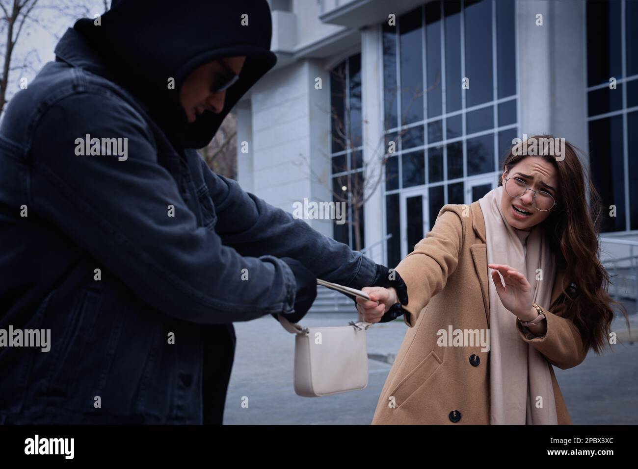 Voleur essayant de voler le sac de femme dans la rue de la ville Banque D'Images