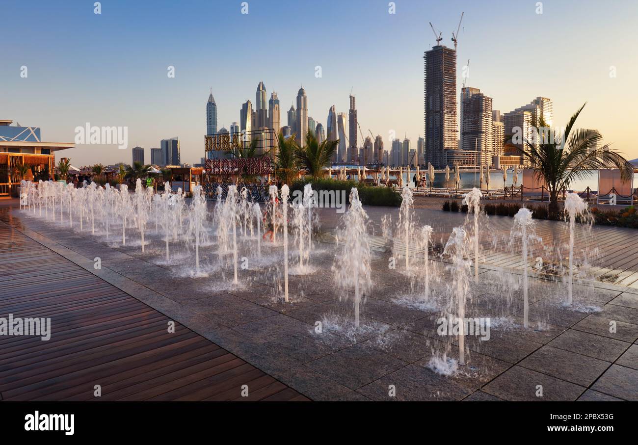 Dubai Marina avec vue sur la ville et fontaine - luxe et célèbre Jumeirah plage en première ligne au lever du soleil, Émirats arabes Unis Banque D'Images