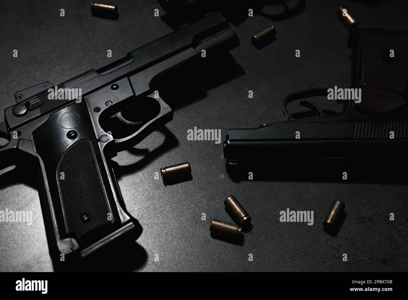 Différents pistolets et balles sur table grise Banque D'Images