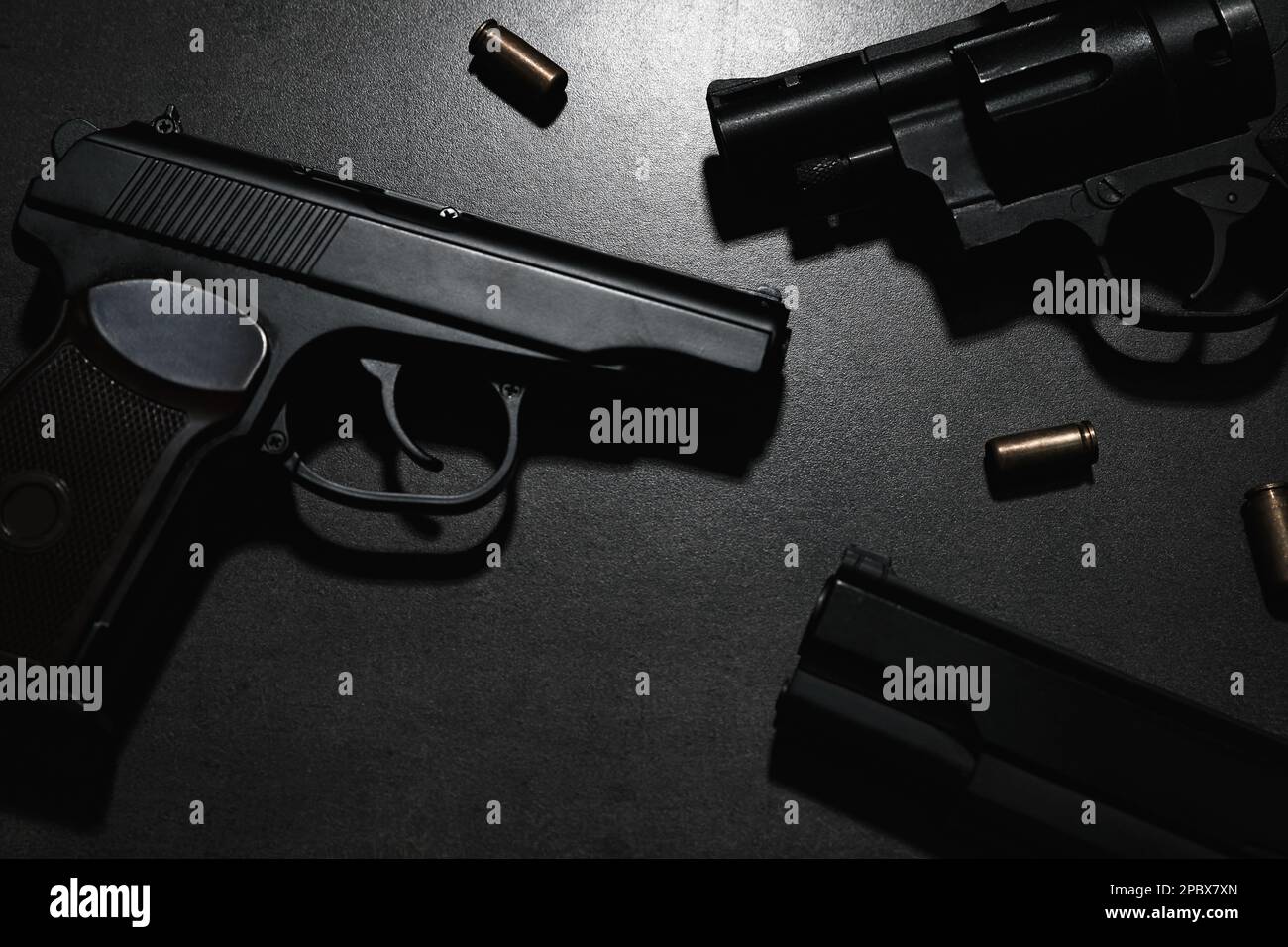 Différents pistolets et balles sur table grise Banque D'Images