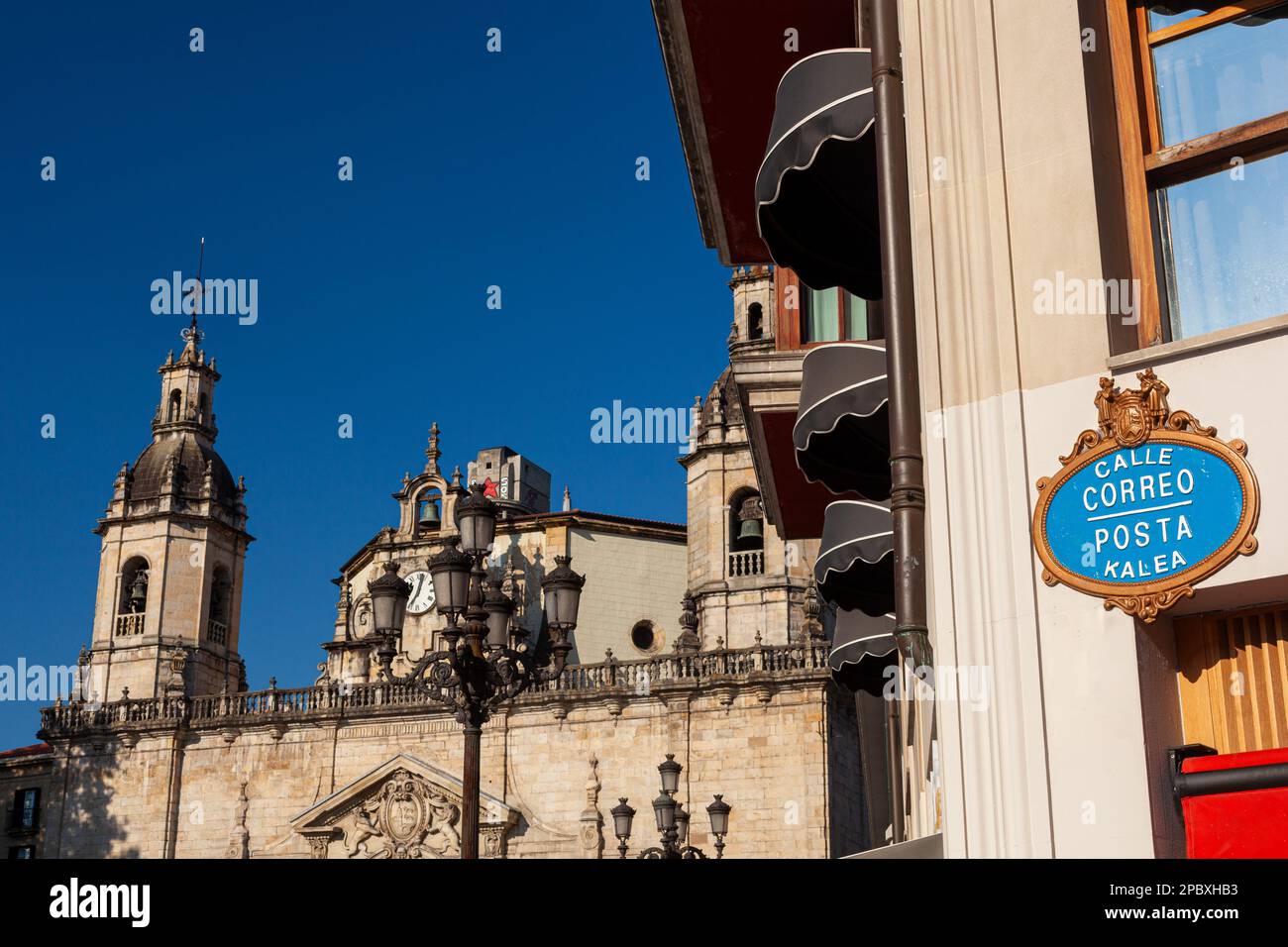 Plaque de nom de rue dorée et bleue au coin de la Calle Correo avec l'église San Anton en arrière-plan Banque D'Images