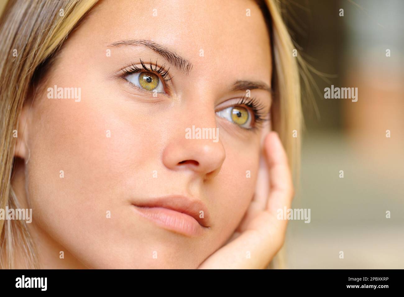 Gros plan d'une femme distraite avec de beaux yeux en regardant loin Banque D'Images