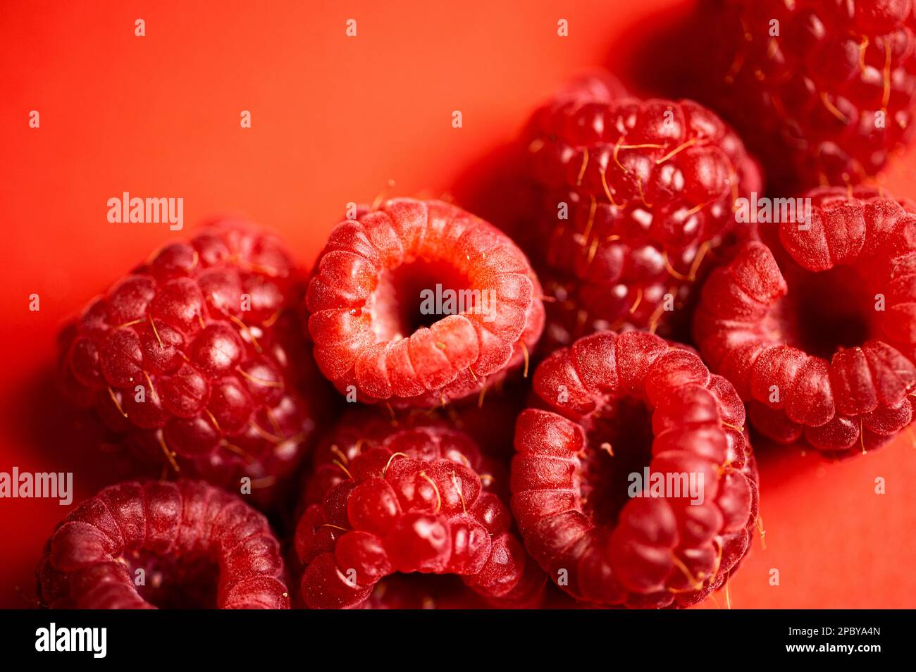 Des framboises rouges douces fraîches disposées ensemble représentant le concept d'une alimentation saine Banque D'Images