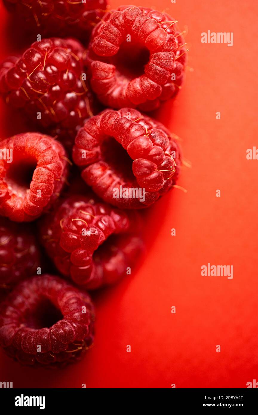 Des framboises rouges douces fraîches disposées ensemble représentant le concept d'une alimentation saine Banque D'Images