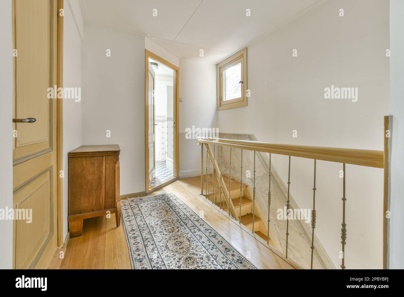 Intérieur d'appartement moderne avec mobilier en bois et murs blancs avec escalier à l'étage supérieur bien éclairé Banque D'Images