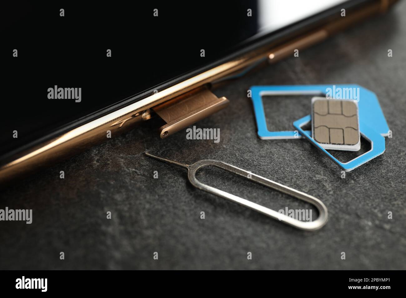 Carte SIM, téléphone portable et outil d'éjection sur table grise, gros  plan Photo Stock - Alamy
