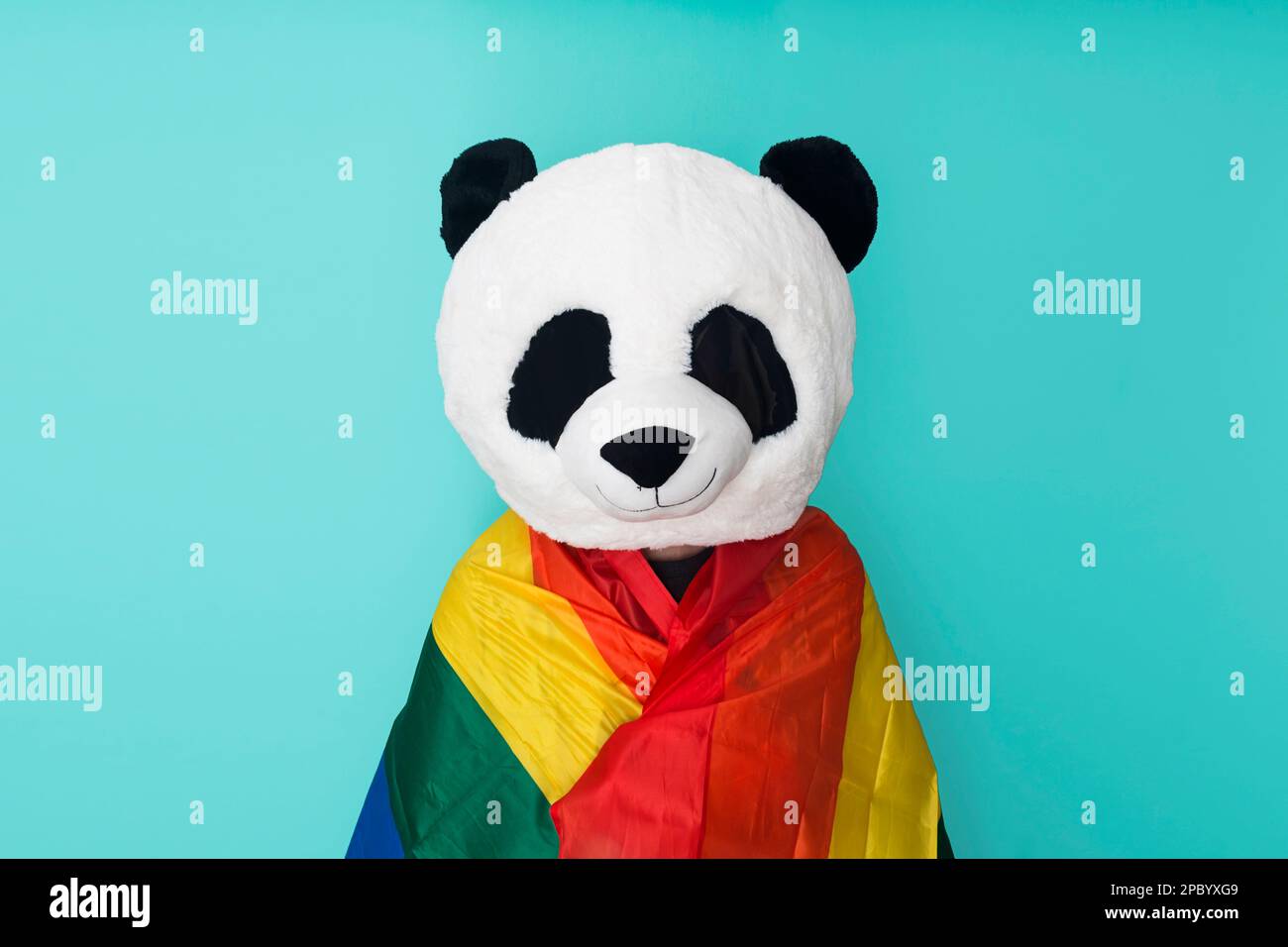 Personne heureuse et méconnaissable enveloppée d'un drapeau arc-en-ciel Banque D'Images