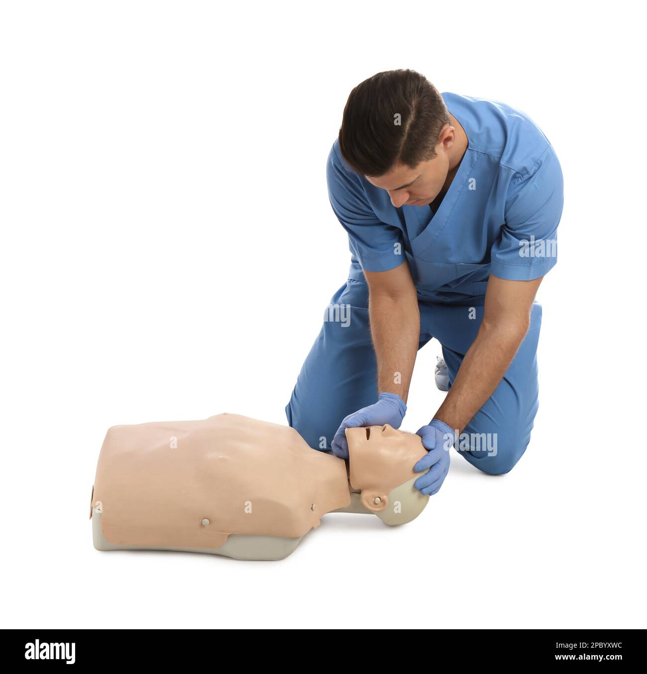 Médecin en uniforme pratiquant les premiers soins sur un mannequin sur fond blanc Banque D'Images