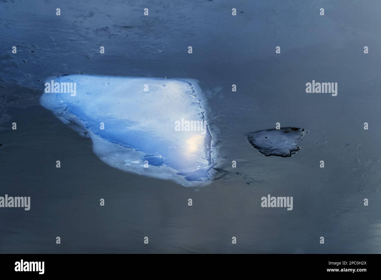 Véritable grande floe de glace blanche dans l'eau sombre hiver nuageux jour Banque D'Images