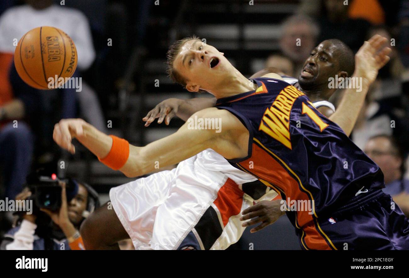 Golden State Warriors' Andris Biedrins (1), of Latvia, and Charlotte Bobcats' Raymond Felton get tangled as they vie for a rebound during the first quarter of an NBA basketball game in Charlotte, N.C., Saturday, Feb. 3, 2007. (AP Photo/Chuck Burton) Banque D'Images