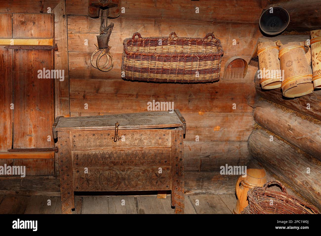 Ustensiles de ménage anciens dans le couloir d'une ancienne cabane rurale dans les rayons pénétrants de lumière et d'ombre. Banque D'Images