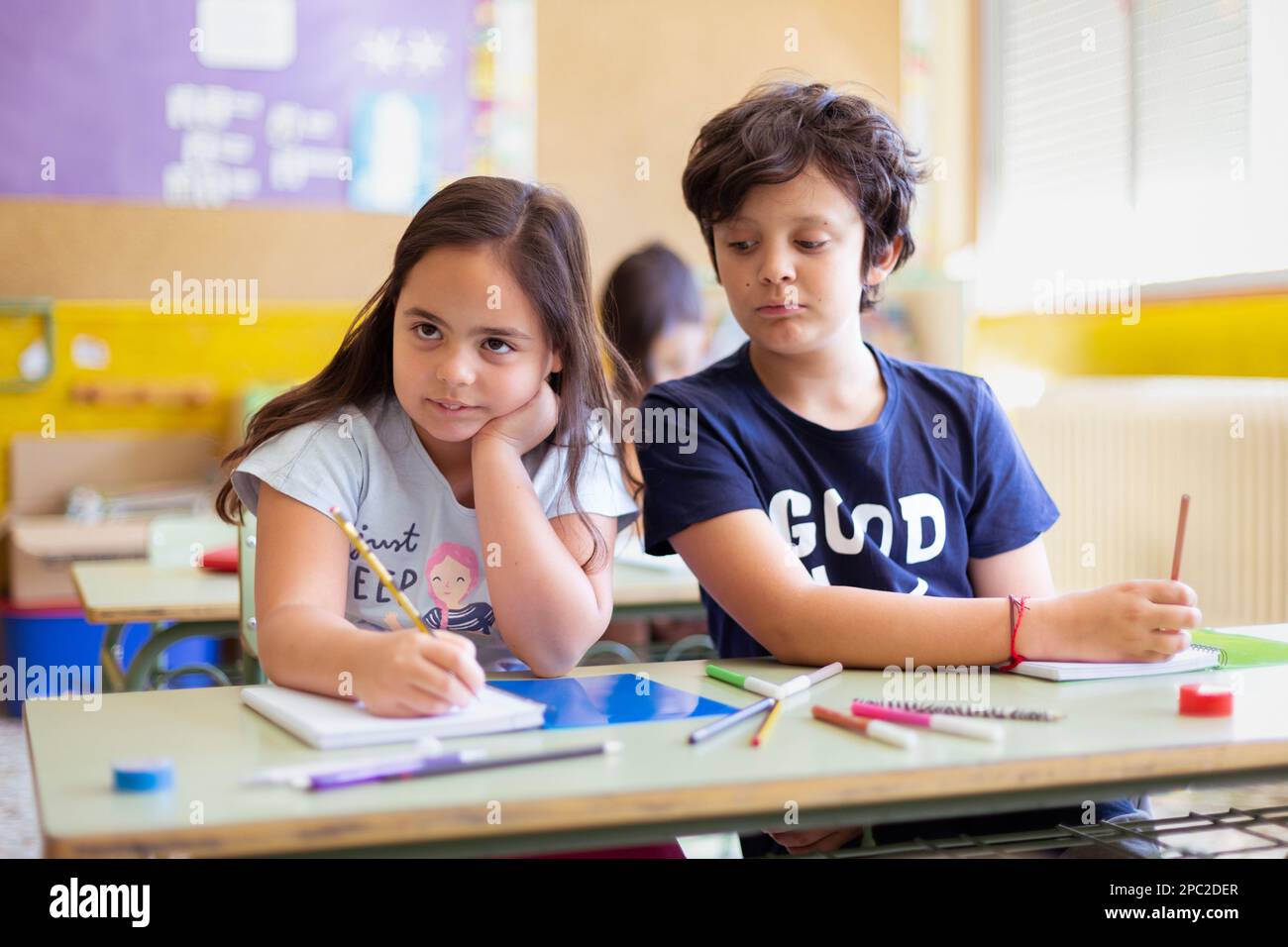 Garçon et fille caucasien à l'école. Les camarades de classe apprennent ensemble. Enseignement primaire et développement de l'enfant. Banque D'Images