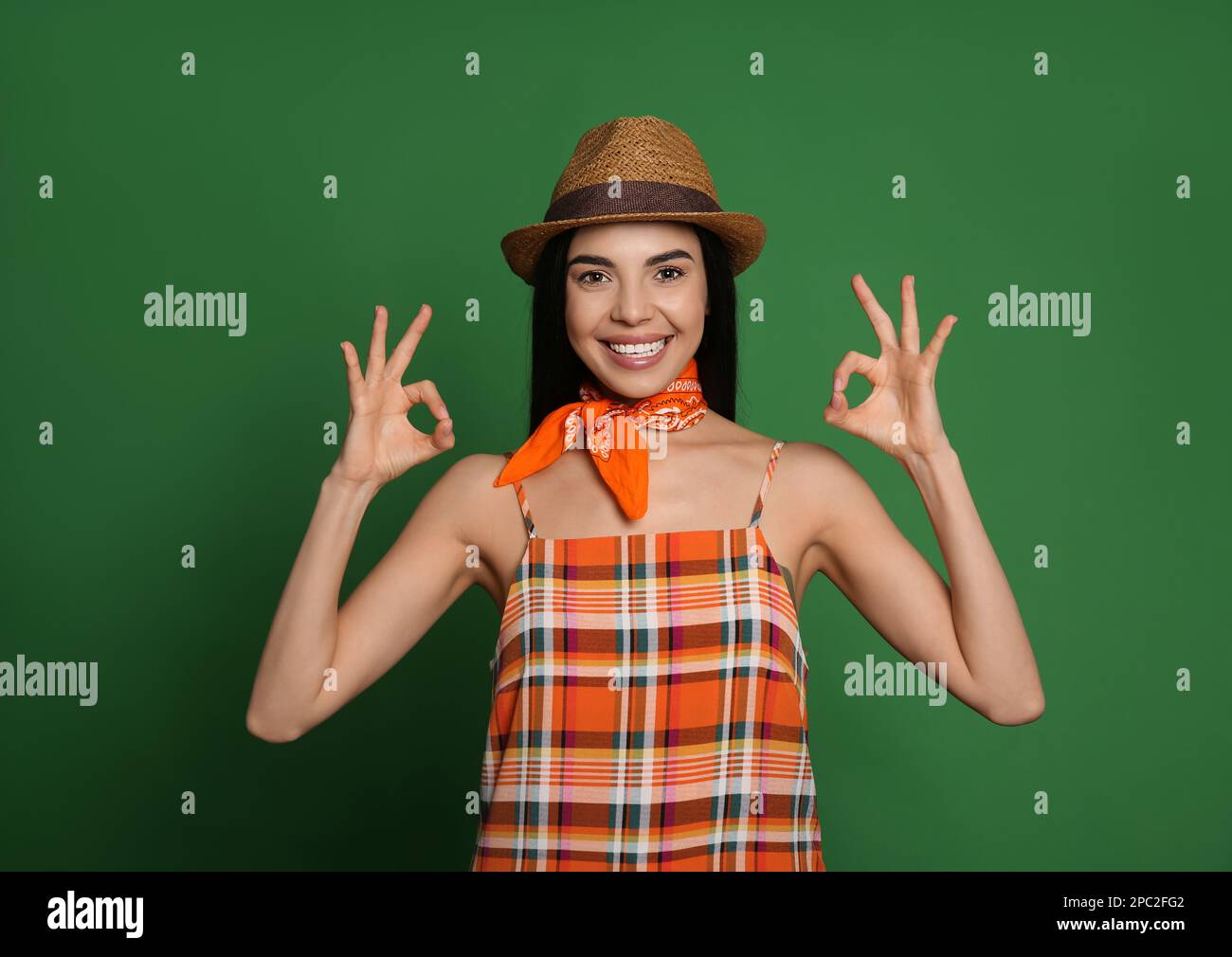 Jeune femme tendance avec une tenue élégante et un bandana sur fond vert Banque D'Images