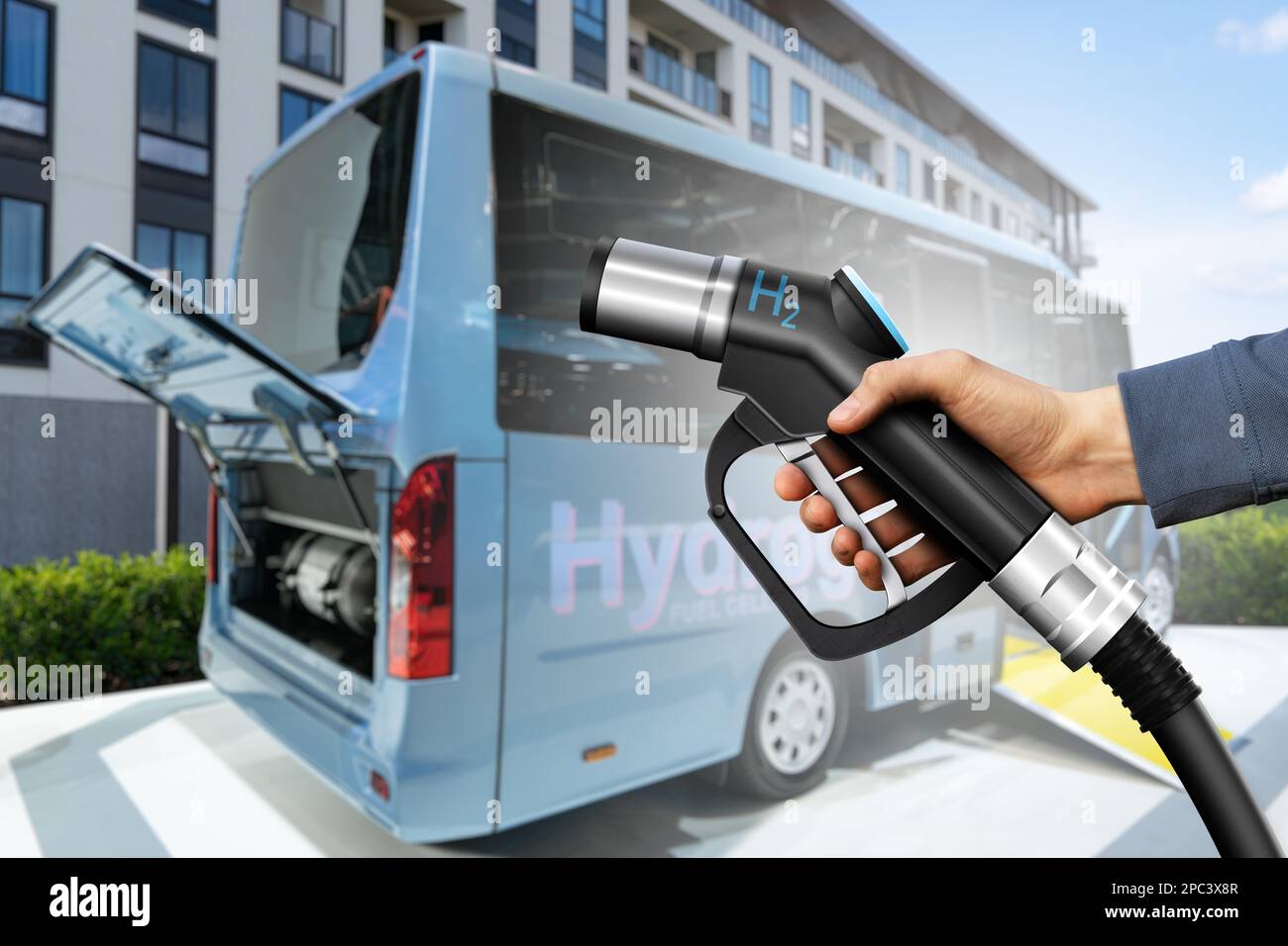 Main avec buse à hydrogène et bus avec capot ouvert et H2 cylindres à l'intérieur. Concept de mobilité propre Banque D'Images