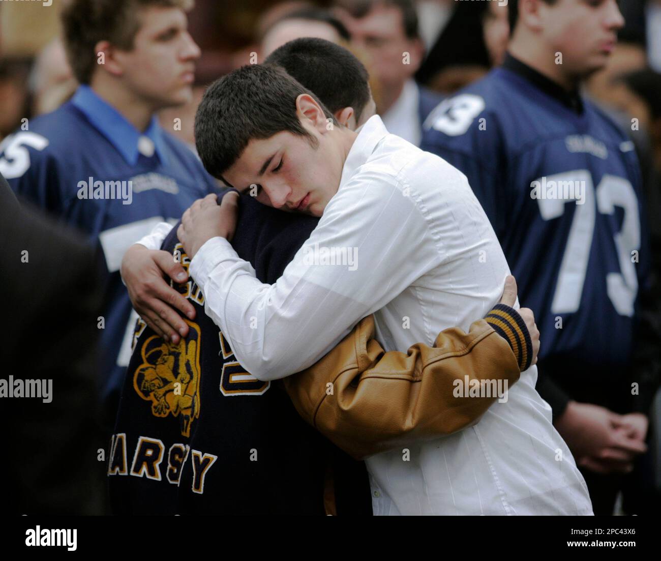 Mourners in football jerseys and a varsity jacket gather outside the Saint Rose of Lima Church in Freehold Borough, N.J., Monday, Jan. 15, 2007, after funeral services for Michael Dragonetti. Dragonetti, captain of the high school football team, is one of four people, three fellow Freehold Borough High School students and a school van driver, killed in a two vehicle crash last week. (AP Photo/Mike Derer) Banque D'Images