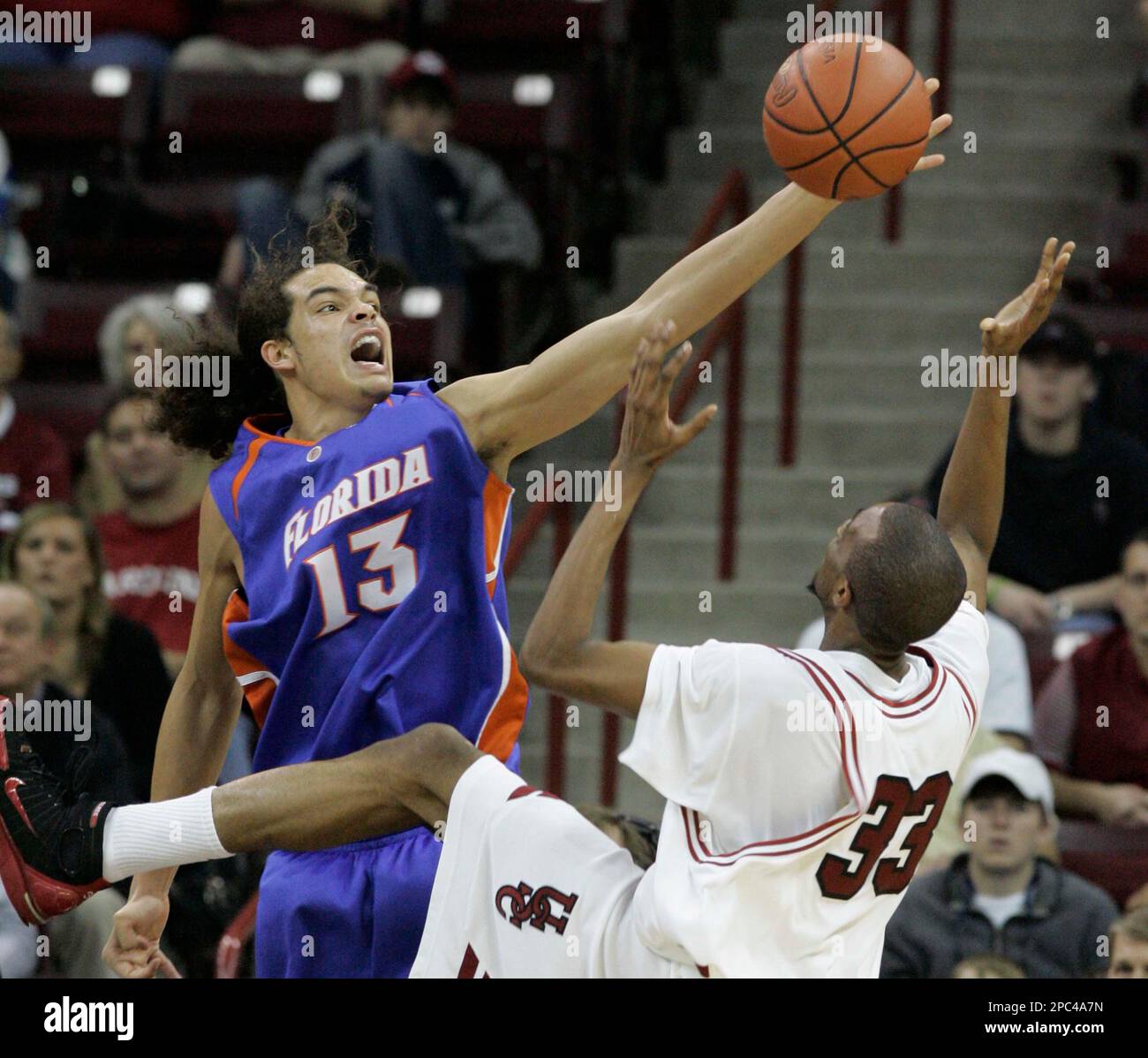Florida's Joakim Noah (13) blocks a shot by South Carolina's Brandon Wallace (33) during the second half of their college basketball game Saturday, Jan. 13, 2007, at the Colonial Center in Columbia, S.C. Florida defeated South Carolina 84-50.(AP Photo/Mary Ann Chastain) Banque D'Images