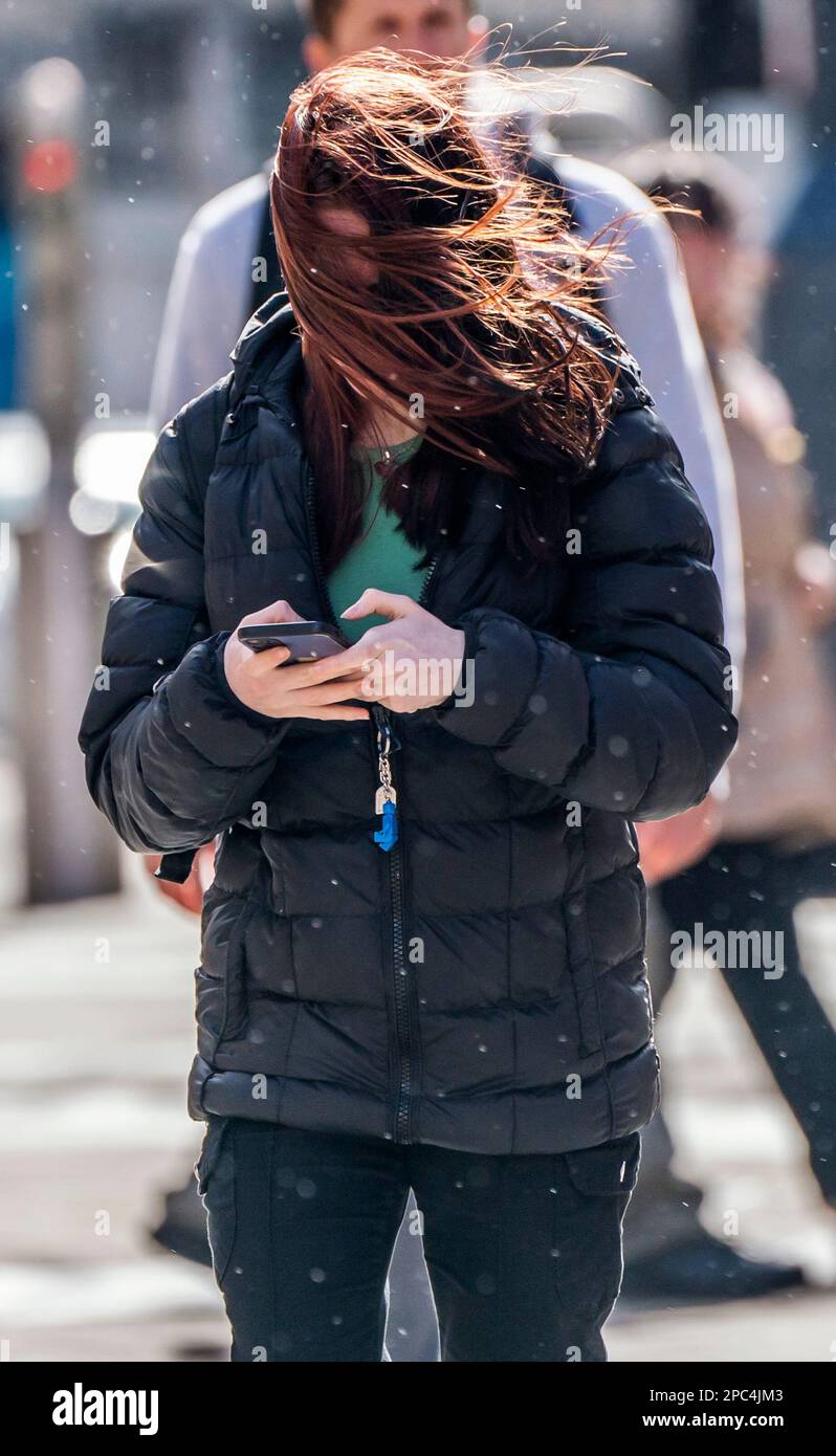 Les cheveux d'une femme sont soufflés par le vent à Leeds, alors que de forts vents frappent le Royaume-Uni. Date de la photo: Lundi 13 mars 2023. Banque D'Images