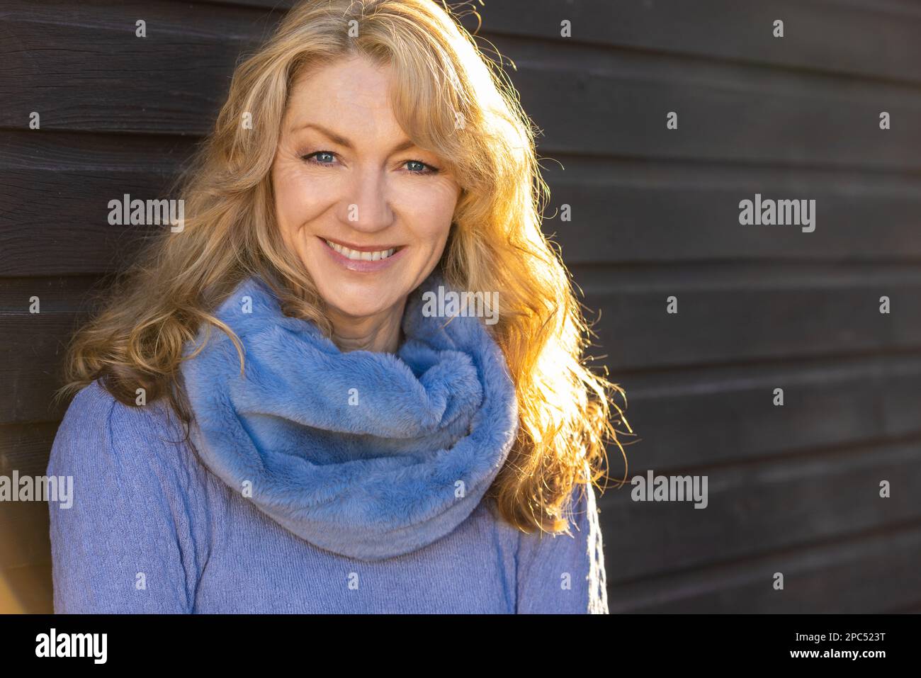 Belle femme heureuse souriante d'âge moyen dehors sous un soleil chaud au coucher du soleil ou au lever du soleil Banque D'Images