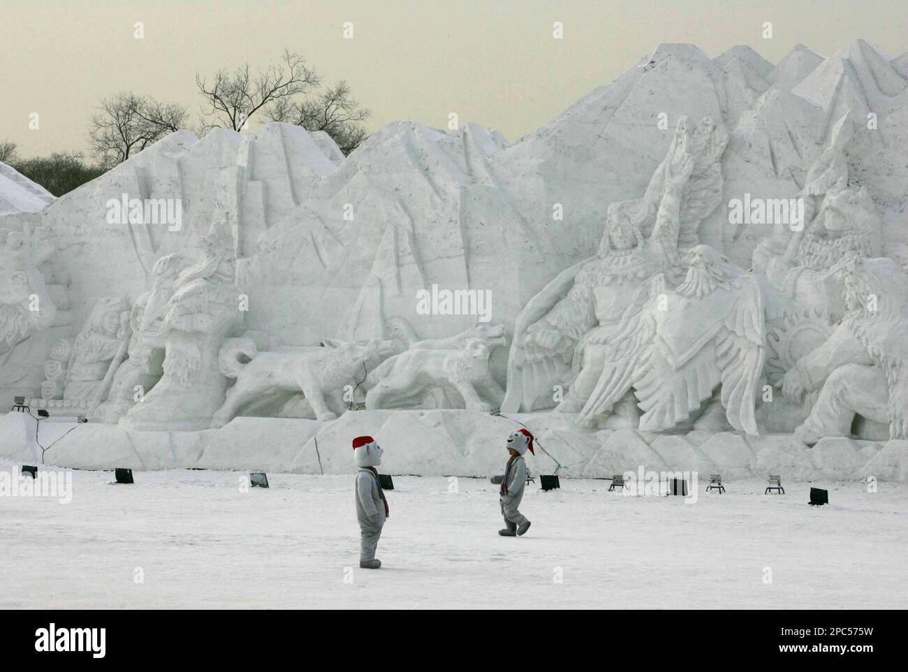 Two Chinese men dressed like snowmen walk near large snow sculptures depicting Canadian culture as the city prepares for its famous Ice and Snow Festival in Harbin, the capital city of China's northernmost province, Heilongjiang in China Friday Jan. 5, 2007. The Ice and Snow festival is one of the largest of its kind in the world. Braving temperatures that can reach 35 degrees Celsius below zero (-31 degrees Fahrenheit) tourist flock by the thousands to enjoy the ice carvings and snow sculptures. (AP Photo/Elizabeth Dalziel) Banque D'Images