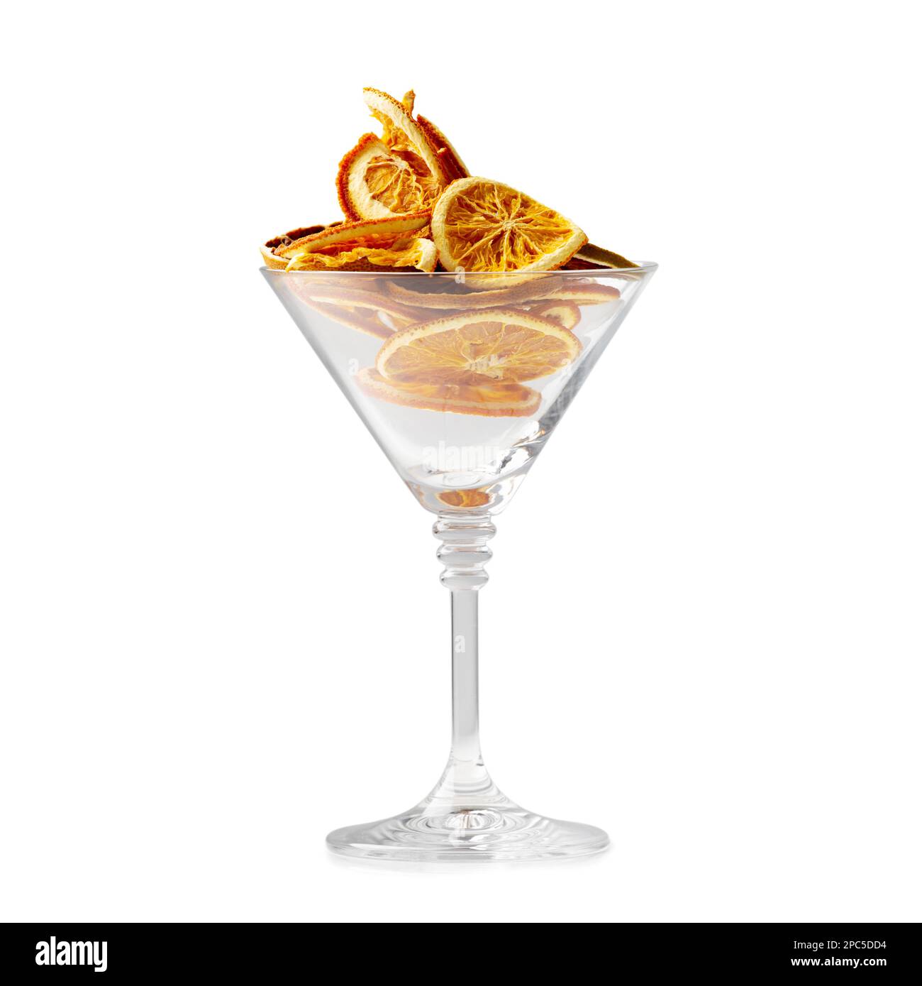 Copeaux d'orange secs isolés. Des éclats d'orange dans un verre de martini sur fond blanc. Une alimentation adéquate. Chips de fruits. Tranches sèches d'agrumes. Banque D'Images