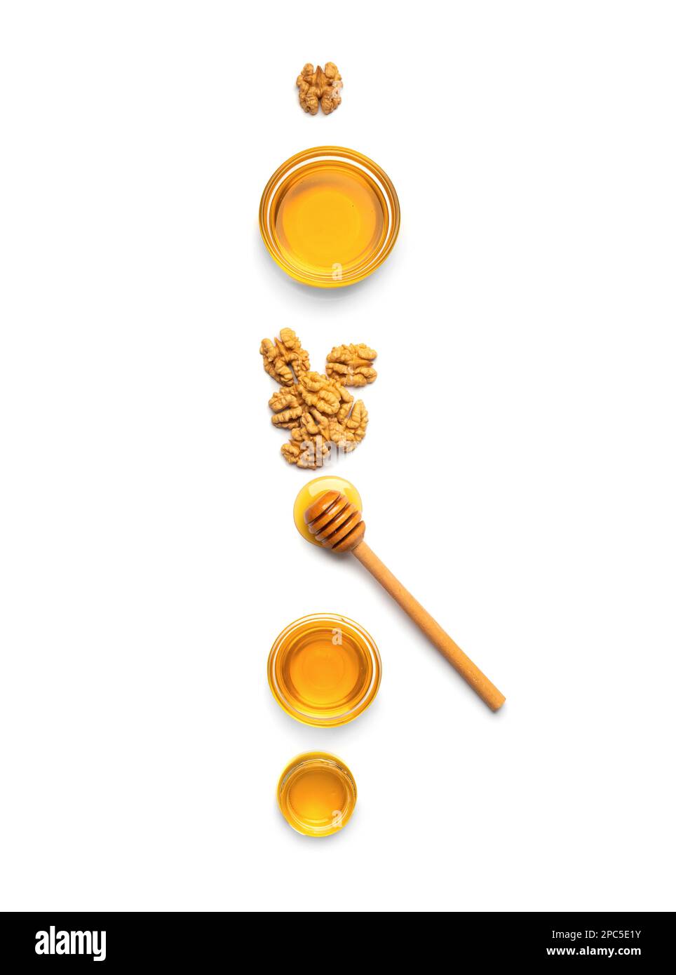 Pots en verre avec miel, noix et un bâton pour miel sur fond blanc. Composition du miel et des noix isolées. Une alimentation saine. Produits biologiques. Banque D'Images