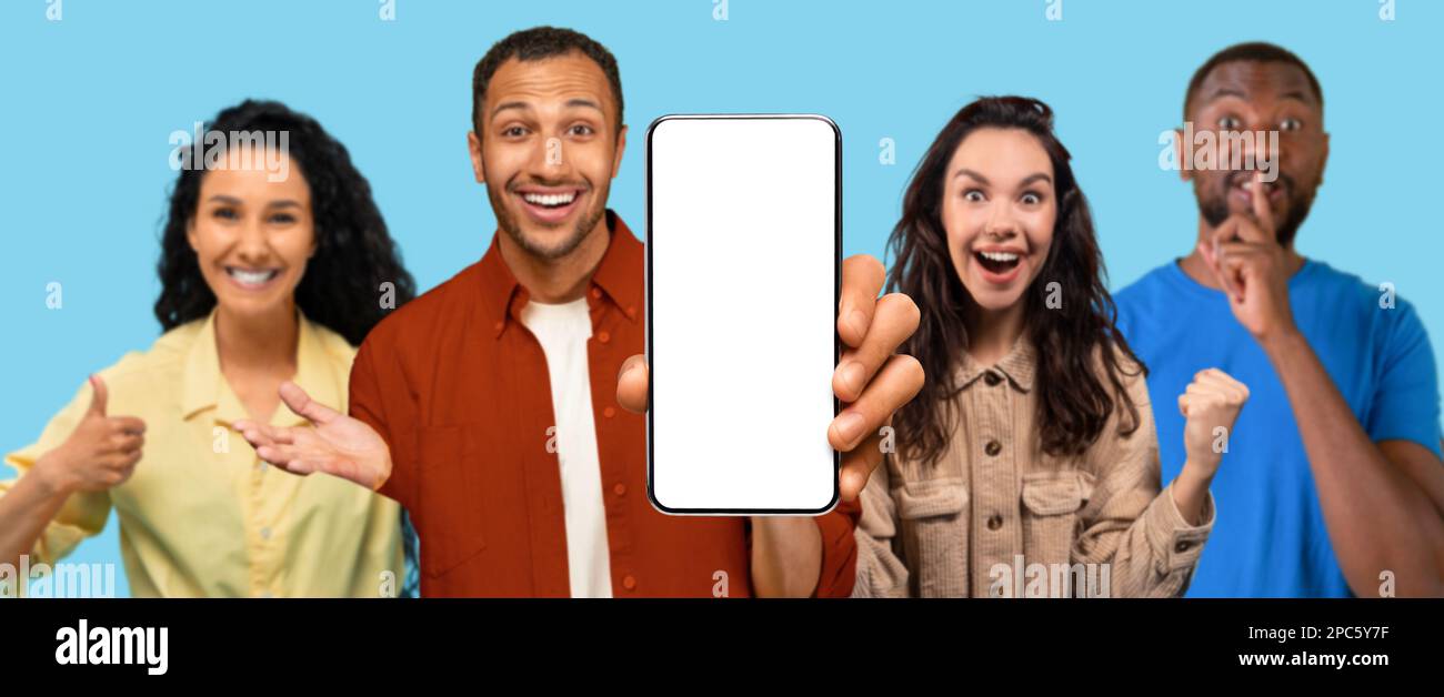Heureux excité surpris jeune noir, arabe, les gens européens montrent le pouce et le téléphone avec écran vide Banque D'Images