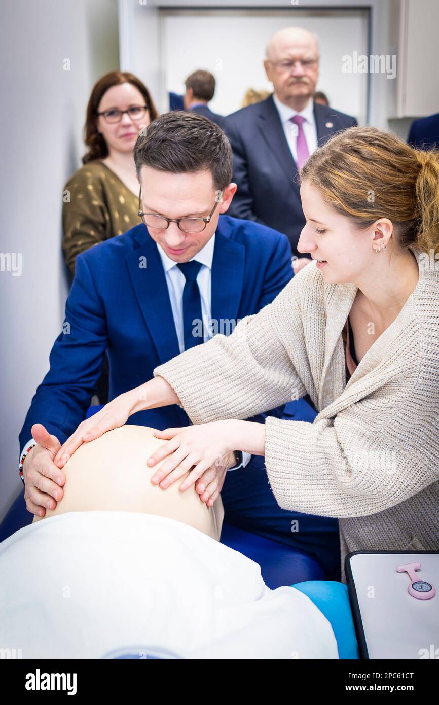 Hanovre, Allemagne. 13th mars 2023. Falko Mohrs (SPD, l), ministre de la Science et de la Culture de Basse-Saxe, s'entretient avec des conférenciers et des étudiants simulant un examen d'une femme enceinte sur un mannequin lors de sa visite dans un laboratoire de formation ('ShillsLab') pour les sages-femmes potentielles à l'école médicale de Hanovre (MHH). Credit: Moritz Frankenberg/dpa/Alay Live News Banque D'Images