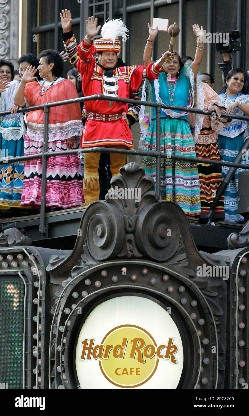 Members of the Seminole Indian Tribe, including medicine man Bobby Henry, center, (wearing red) celebrate their good fortune atop the Hard Rock Cafe marquis in Times Square after the tribe announced it had acquired Hard Rock International, marking the first purchase of a major international corporation by a native American Indian tribe, in New York, Thursday, Dec. 7, 2006. The tribe purchased Hard Rock International in a $965 million deal. (AP Photo/Kathy Willens) Banque D'Images