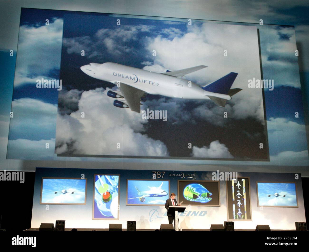 Scott Strode, vice president of airplane development and production for Boeing Co.'s 787 Dreamliner program, stands at a podium, Wednesday, Dec. 6, 2006 in Everett, Wash., as a computer image of the "Dreamlifter," is shown above him. The aircraft is a specially built airplane designed to ferry the large parts of the new 787 airplane from manufacturing points around the world to final assembly points in Everett, Wash. (AP Photo/Ted S. Warren) Banque D'Images