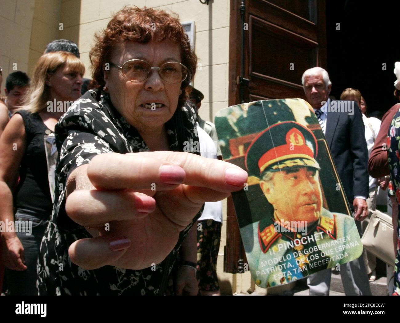 A supporter of former dictator Gen. Augusto Pinochet shows a picture of ...