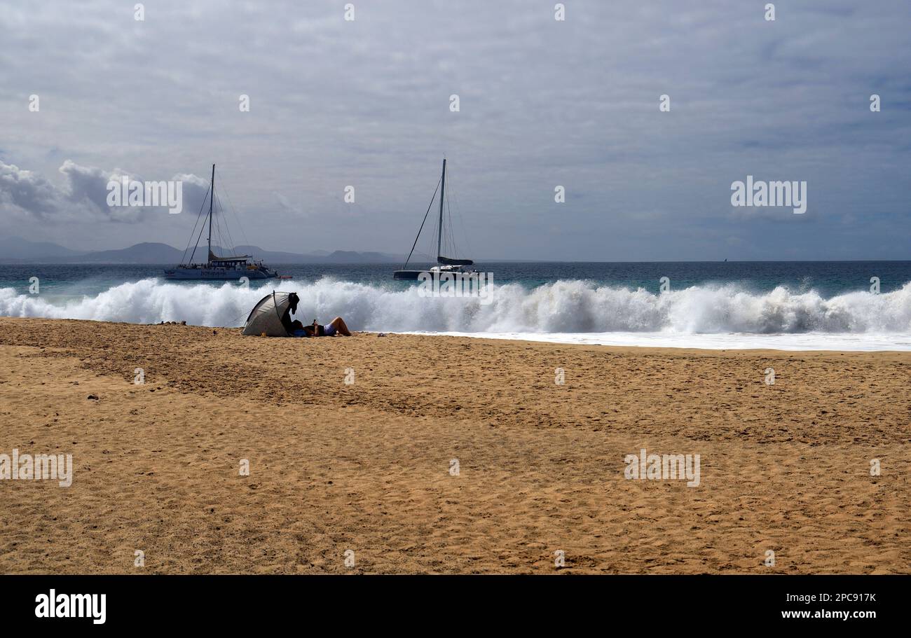 Bains de soleil et mer agitée, Playa Mujeres plage, Playa Blanca, Lanzarote, îles Canaries, Espagne. Banque D'Images
