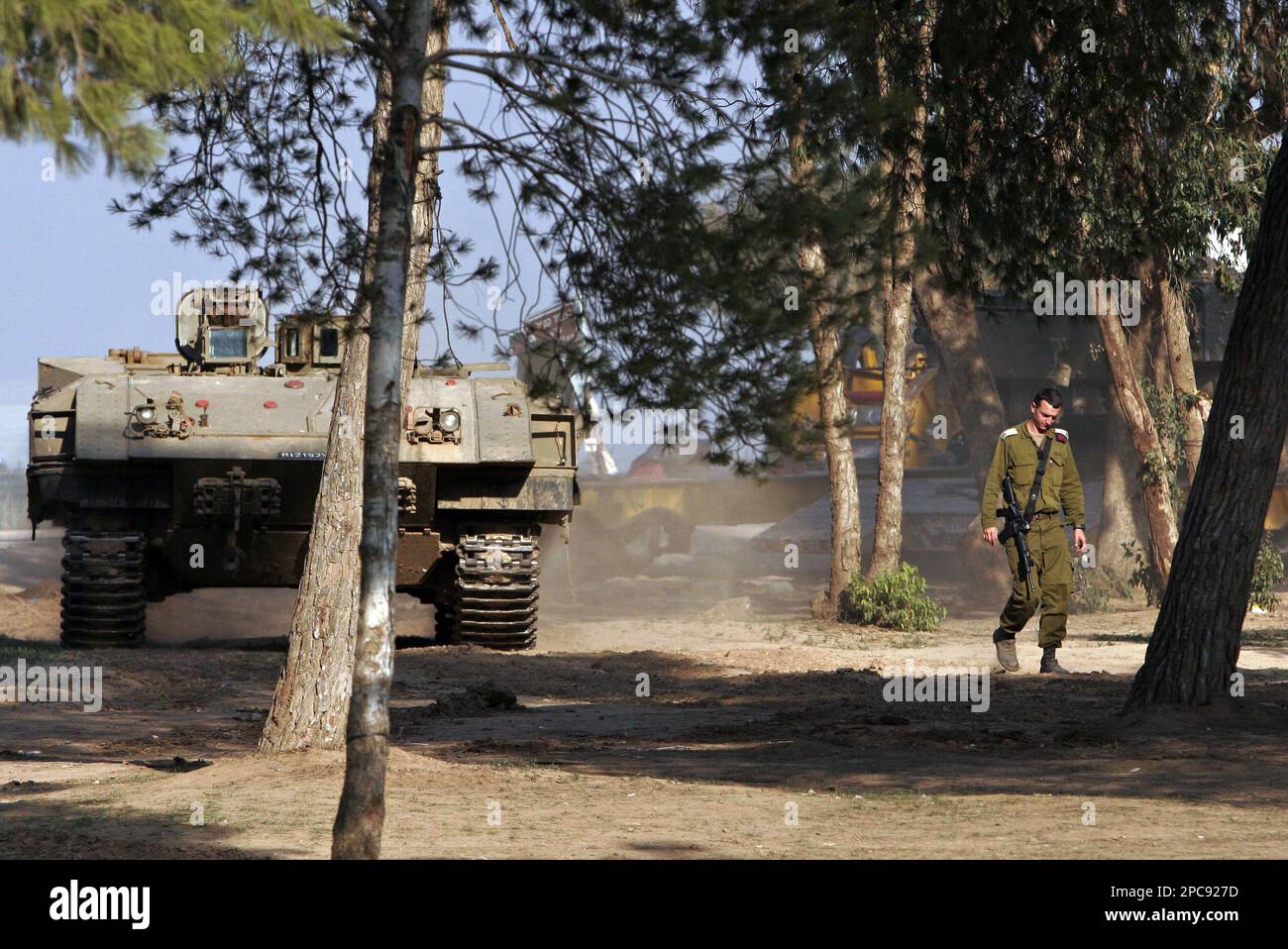 An Israeli soldier walks near an armored vehicle at a staging area just outside the northern Gaza Strip, near Kibbutz Mefalsim, Israel. Thursday, Nov. 30, 2006. United States Secretary of State Condoleezza Rice called on Israelis and Palestinians Thursday to step up efforts to achieve peace. (AP Photo/Tsafrir Abayov) Banque D'Images