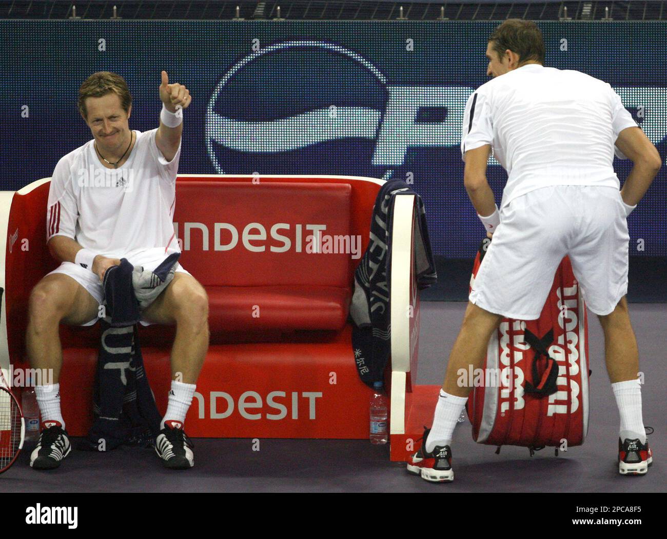 Sweden's Jonas Bjorkman, left, gives a thumbs-up as his partner Belarus' Max Mirnyi looks on as they celebrate after defeating Bahamian Mark Knowles and Canadian Daniel Nestor 6-2, 6-4 in their men's doubles final at the Masters Cup tennis tournament in Shanghai, China, Sunday, Nov. 19, 2006. (AP Photo/Ng Han Guan) Banque D'Images